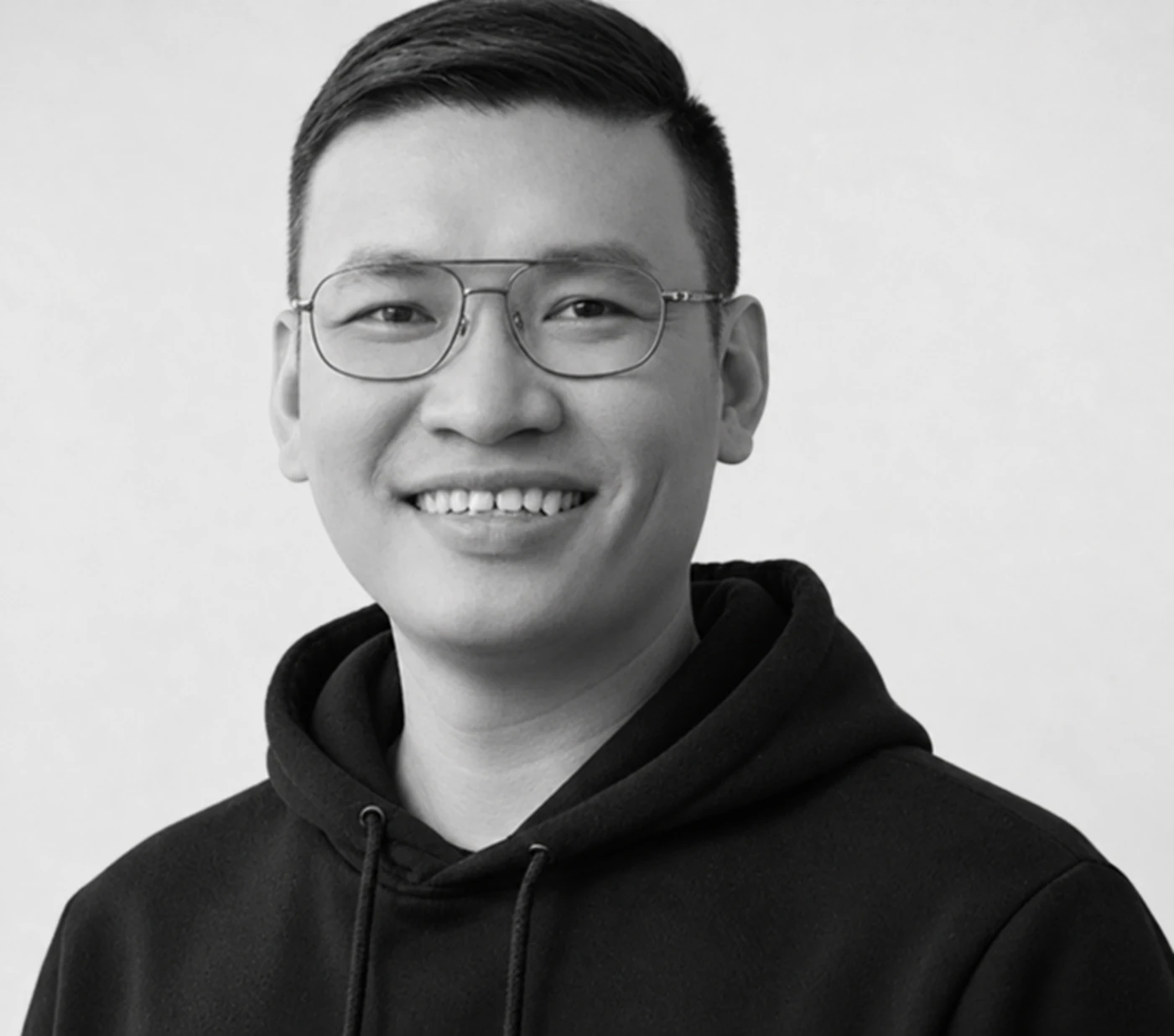 Porträt von Tuan, Entwickler bei AdvoArmy, lächelnd mit Brille