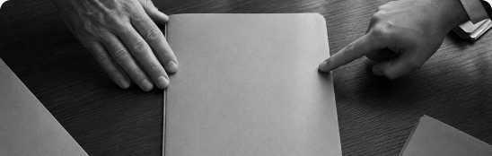 Webdesign für Rechtsanwälte: Zwei Hände an einem leeren Blatt Papier, eine Hand zeigt darauf
