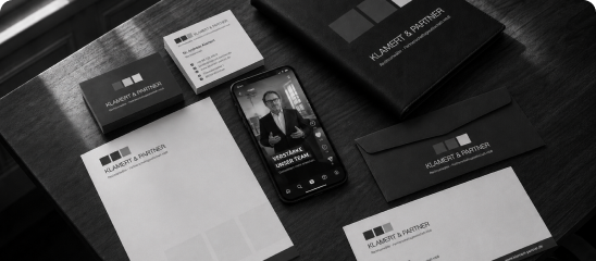 Employer Branding für Kanzleien: Geschäftsausstattung von Klamert & Partner mit Visitenkarten, Briefpapier und Smartphone