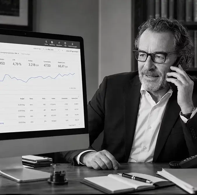 Google Ads für Anwälte: Anwalt telefoniert, auf dem Monitor die Kampagnenübersicht von Google Ads